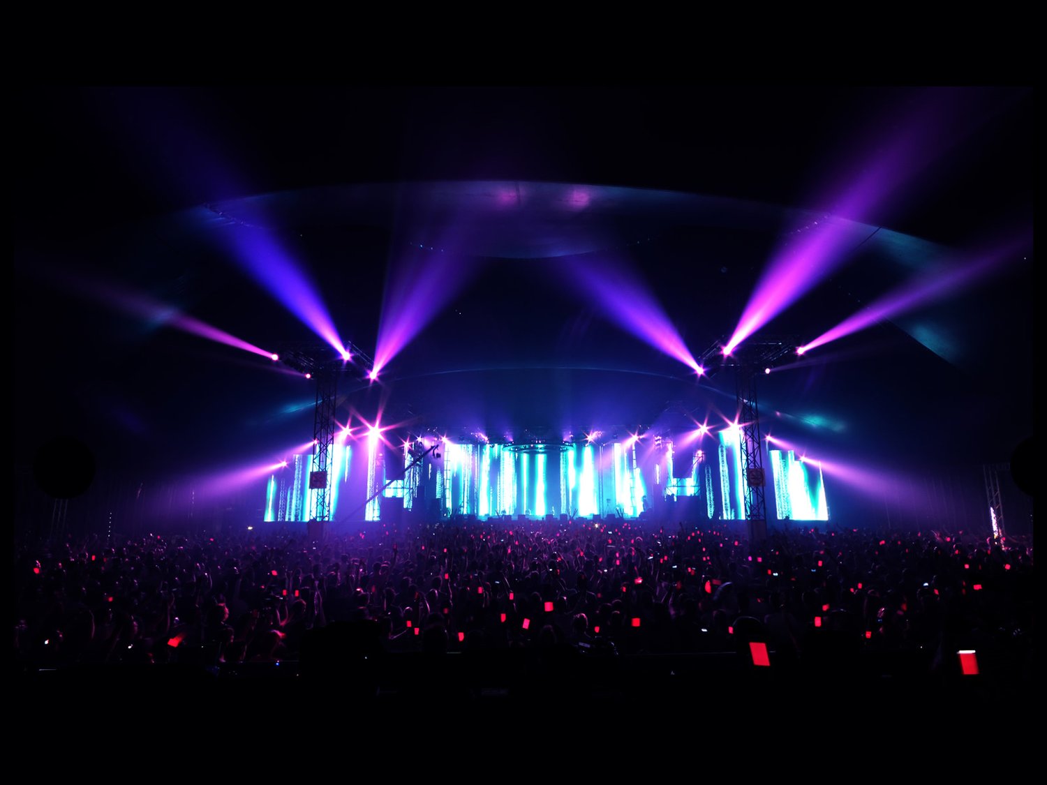 Purple stage lights over the festival crowd